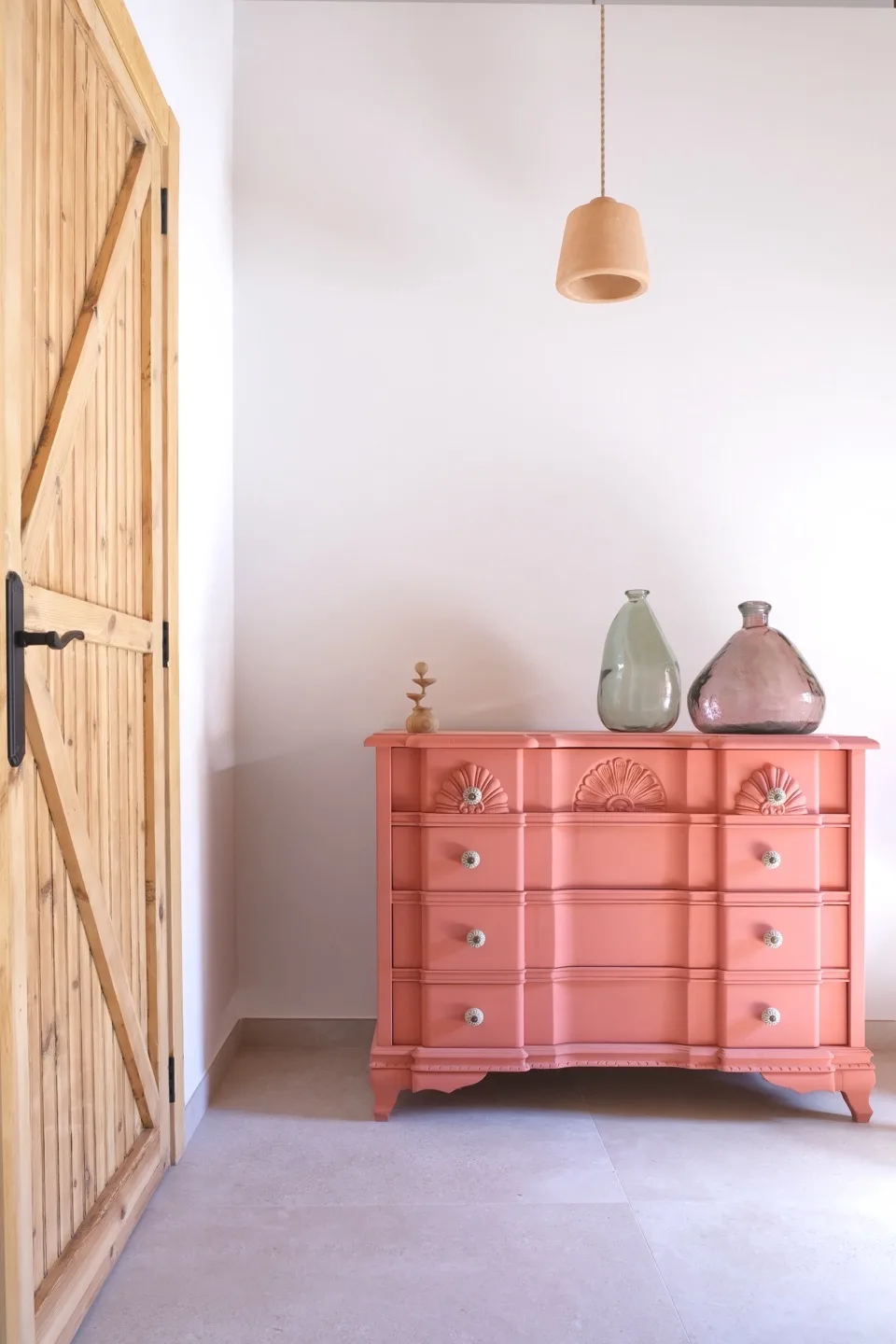 Paraíso — coral pink dresser with glass demijohns and ceramic pendant