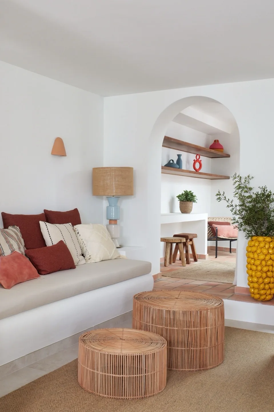 Paraíso — living room with arched doorway, rattan tables, and colourful cushions